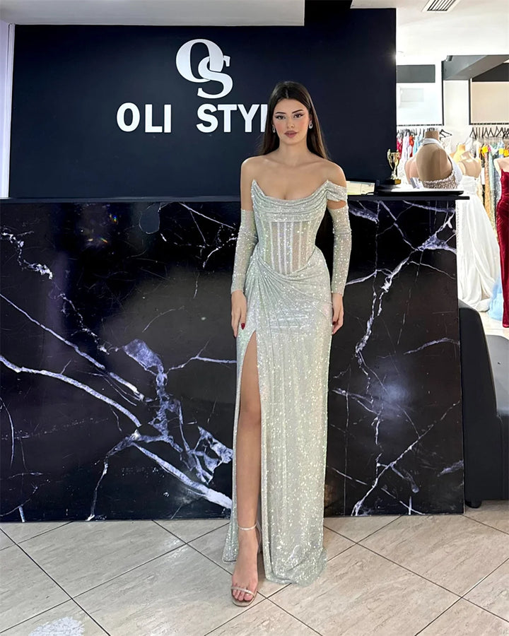 Woman in a sparkling evening gown standing in front of an OLI STYLIST sign.