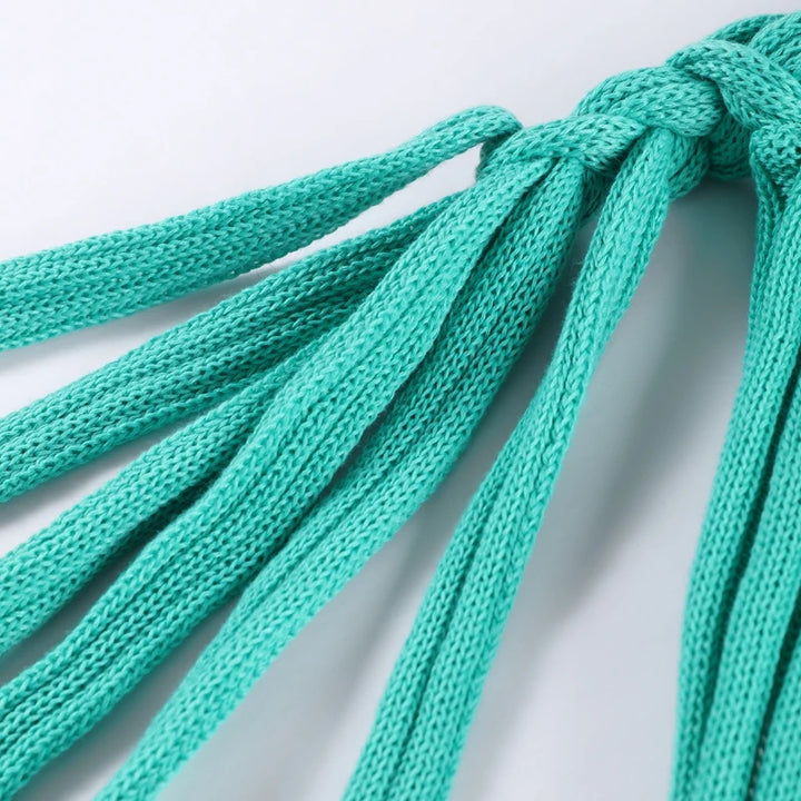 Close-up of teal shoelaces on a light gray background