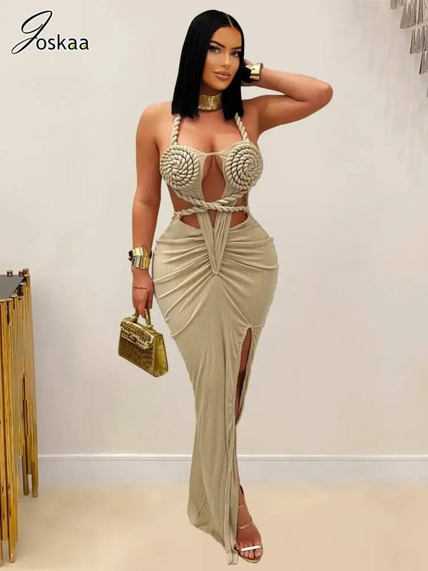 Woman wearing a stylish beige dress with a gold handbag against a plain background
